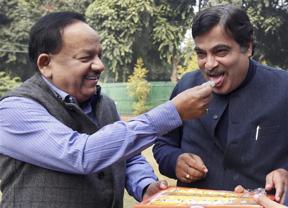 BJP`s Delhi in-charge Nitin Gadkari is greeted by party`s chief ministerial candidate Harsh Vardhan with sweets during a meeting at his residence in New Delhi.