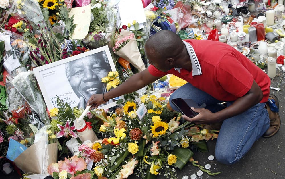 A mourner places a candle outside the home of former president Nelson Mandela in Johannesburg, South Africa.