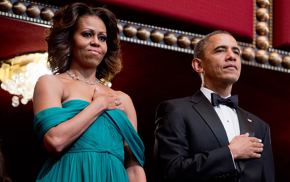 President Barack Obama and first lady Michelle Obama put their hands over their heart as the National Anthem is played during the Kennedy Center Honors Gala at the Kennedy Center in Washington.