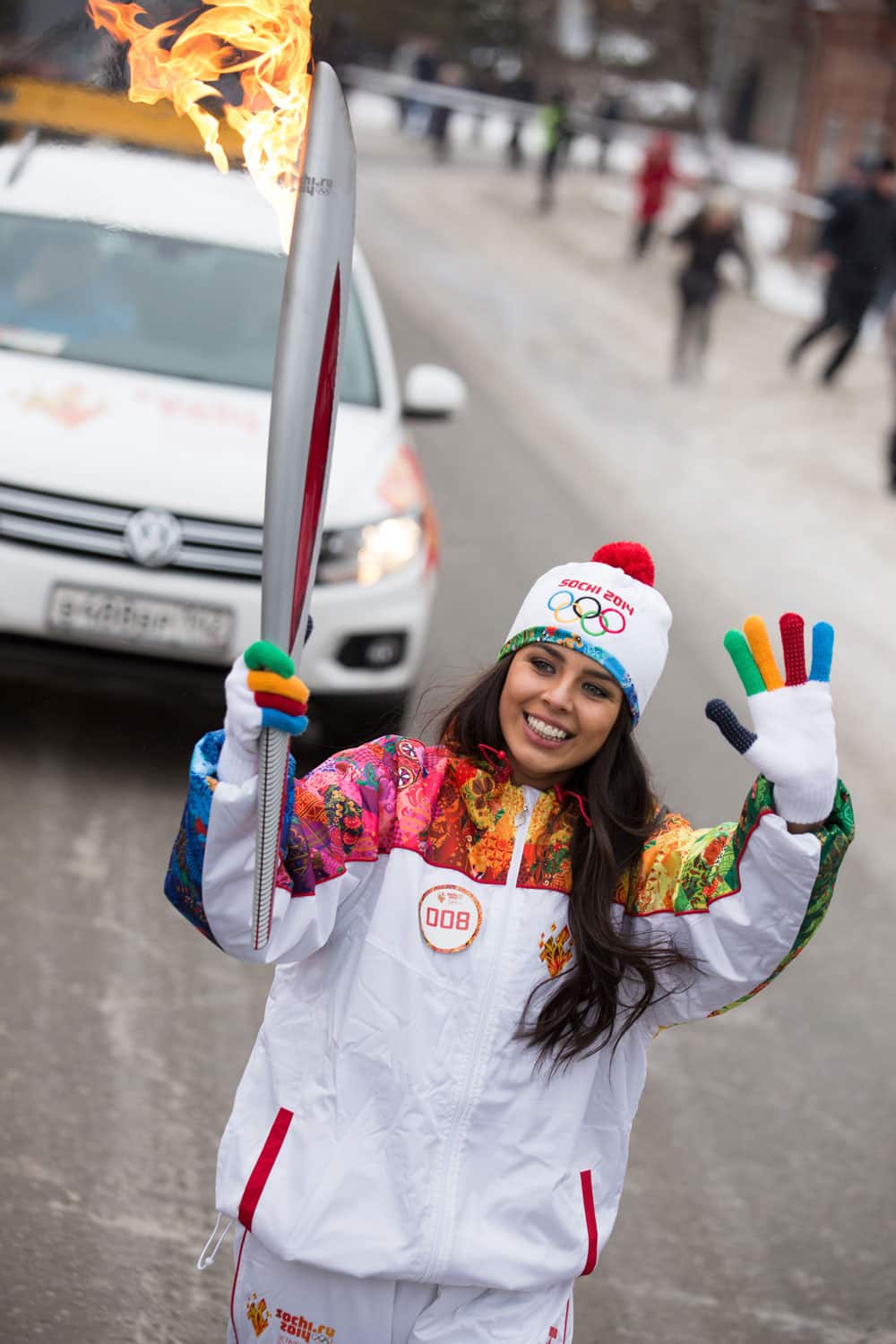 This photo provided by Olympictorch2014.com torch bearer, Miss Russia Elmira Abdrazakova carries an Olympic torch during the Olympic torch relay in Kuibyshev, Novosibirsk region, about 2,500 kilometers (1,550 miles) east of Moscow, Russia.