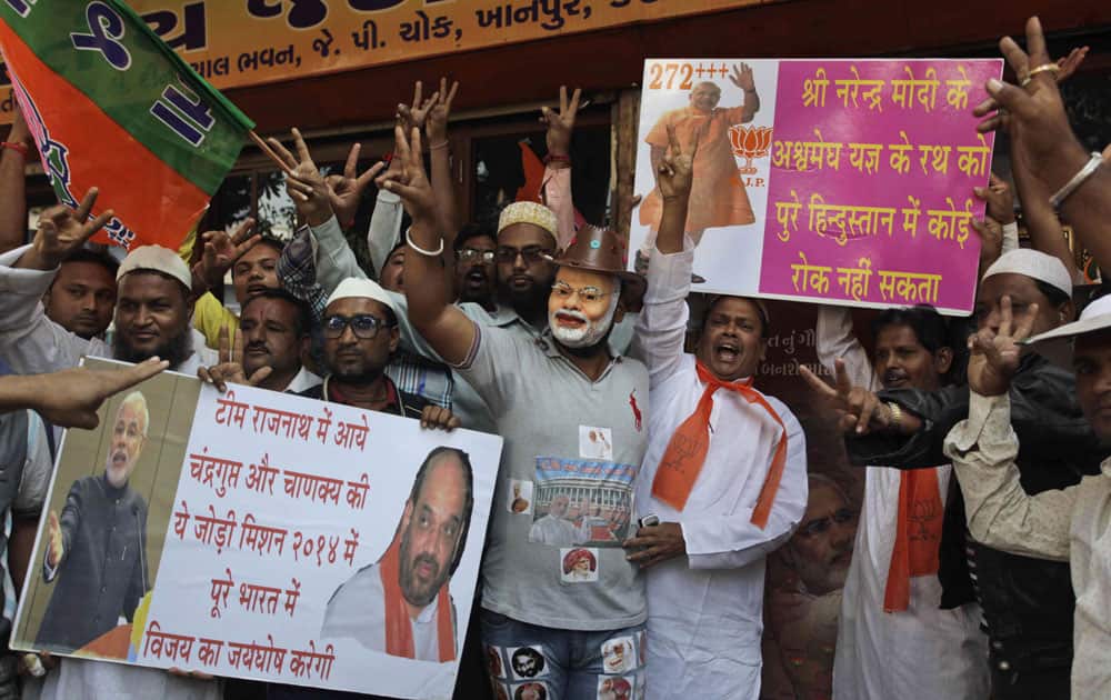 A man, wears a mask of Gujarat Chief Minister Narendra Modi as supporters of India`s main opposition Bharatiya Janata Party (BJP) celebrate the party`s victory in various state Assembly elections, in Ahmedabad.