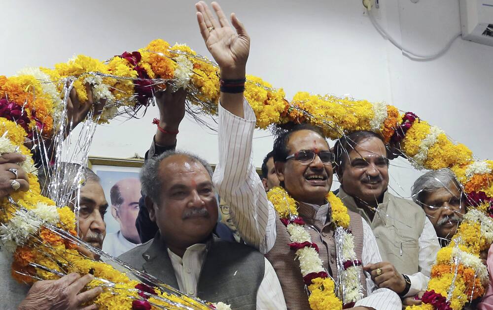 Shivraj Singh Chauhan waves to supporters as he is garlanded with other leaders while celebrating the party’s victory in the state Assembly elections in Bhopal.