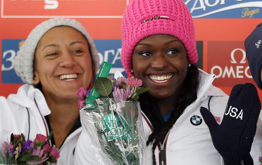 The United States` Elana Meyers, left, and Aja Evans, right, celebrate during a flowers presentation following the women`s bobsledding World Cup event in Park City, Utah.