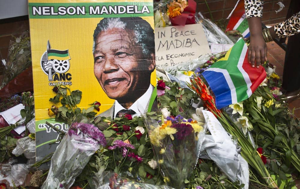 Flowers, posters, and messages left by mourners lie in front of Nelson Mandela`s old house in Soweto, Johannesburg, South Africa.