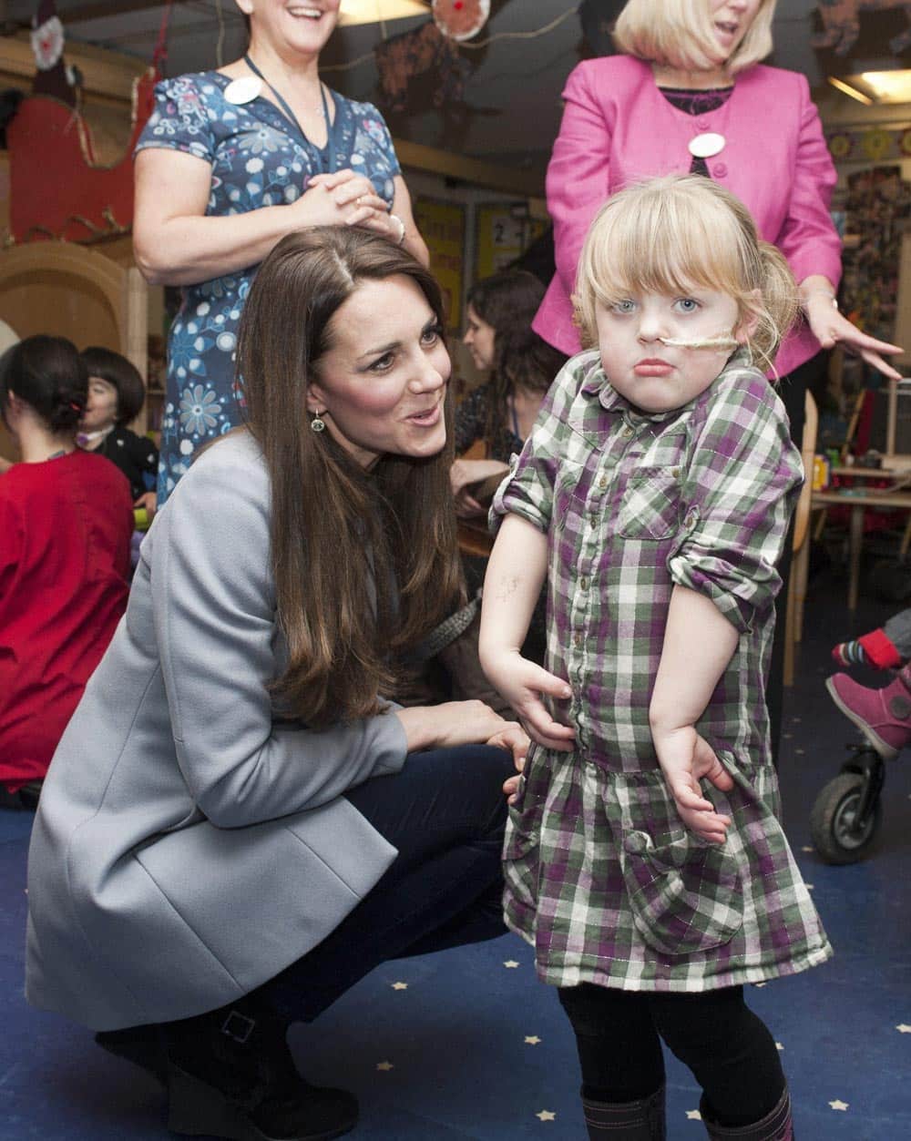 Kate, the Duchess Of Cambridge, left, reacts with a patient as she visits the Shooting Star House Children`s hospice, in London.