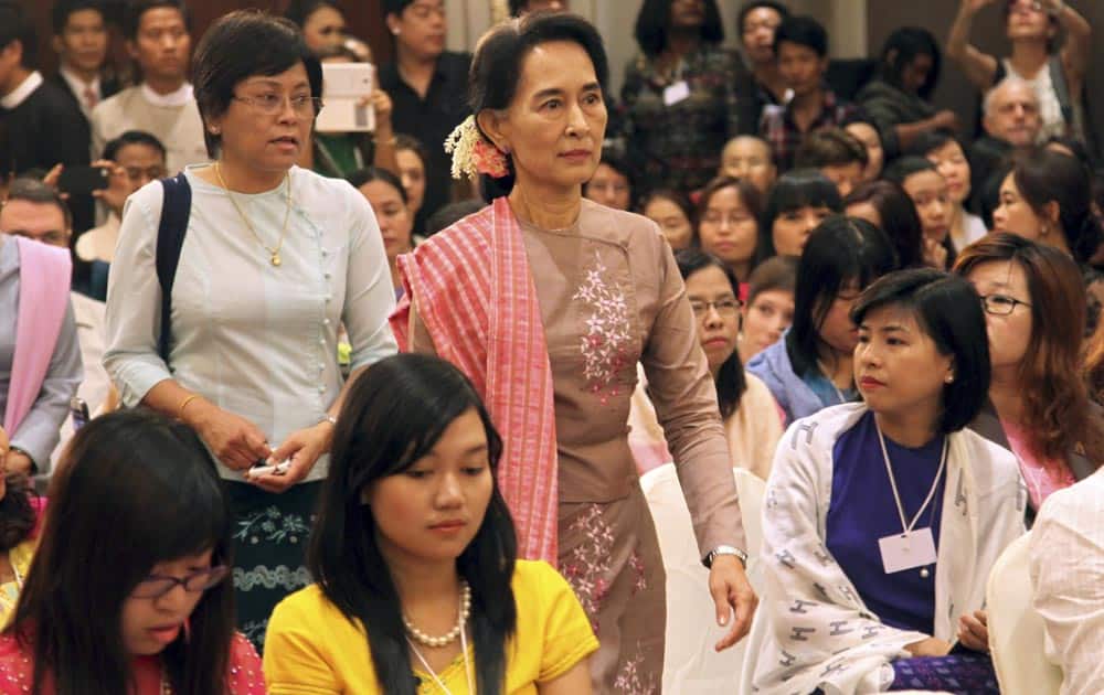 Myanmar opposition leader Aung San Suu Kyi, center, arrives for a dialogue entitled