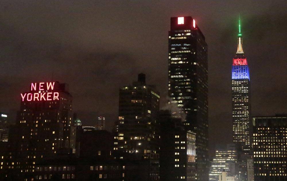 The Empire State Building, right, rises into the climbs into the New York City skyline lit in the colors of the South African Flag to observe the passing of former South African President and Civil Rights leader Nelson Mandela.