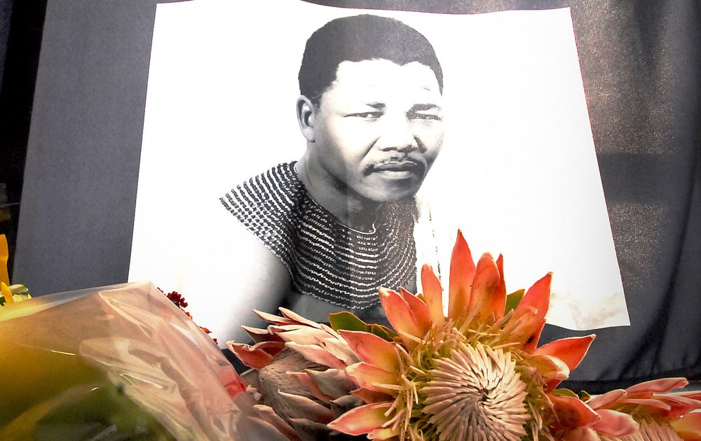 A portrait of a young Nelson Mandela lays alongside a floral tribute in Cape Town, South Africa.