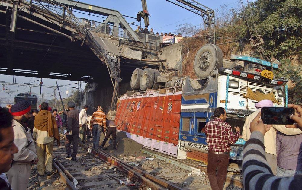 A truck lies upturned on railway tracks after a bridge it was traveling on collapsed in Amritsar.