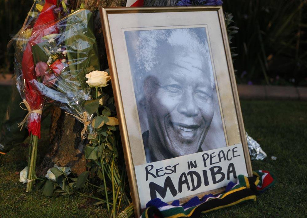 A framed portrait of former president Nelson Mandela and flowers are placed outside Mandela`s Johannesburg home, after the freedom fighter passed away Thursday night after a long illness.