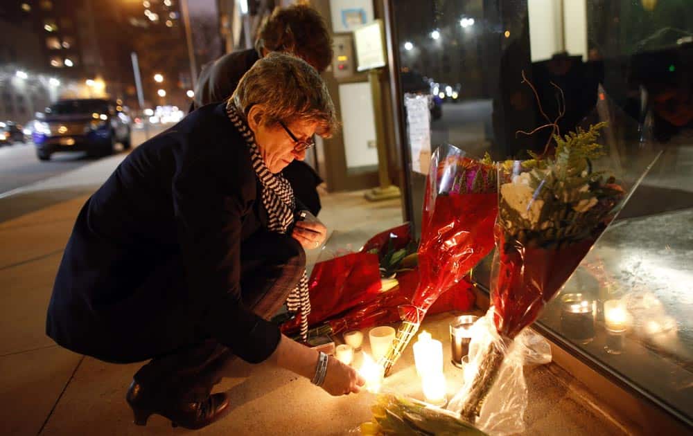 Australian native Kate Gilmore, who now resides in New York, lights candles at a makeshift memorial for South African leader Nelson Mandela outside the South African consulate, in New York.