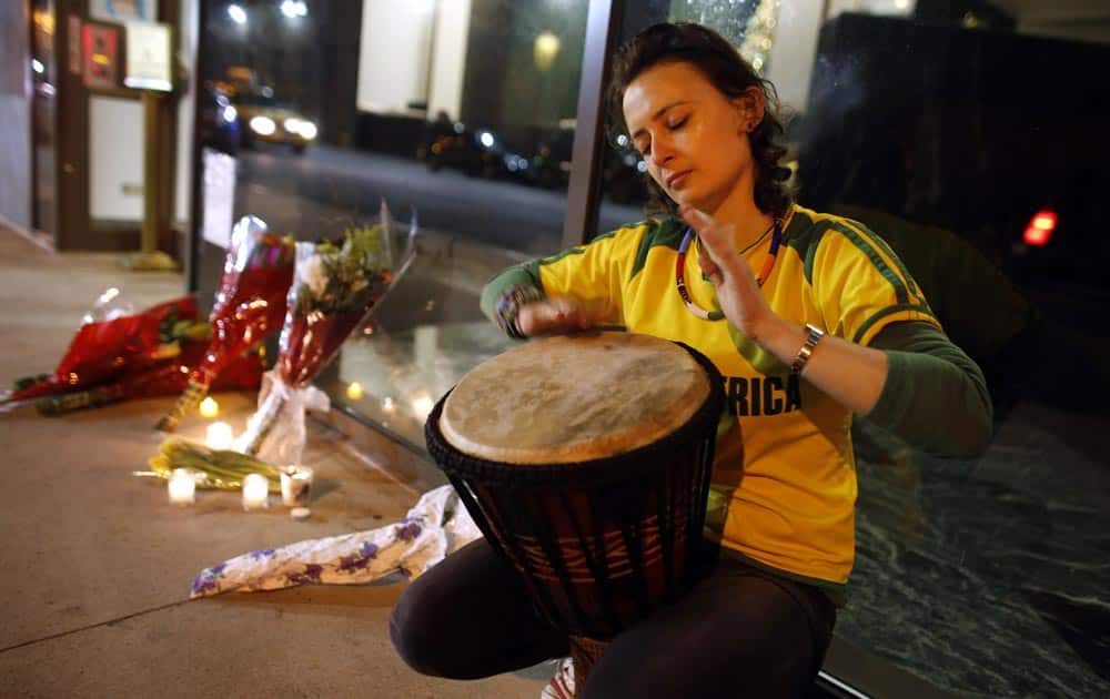 South African native Lorien Miller, who now resides in New York, plays a traditional African djembe drum next to a makeshift memorial for South African leader Nelson Mandela outside the South African consulate, in New York.