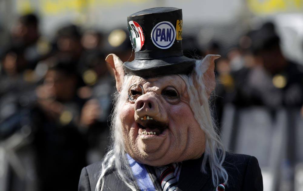 A demonstrator wearing a pig’s mask, protests against a proposed energy reform bill near the Senate building in Mexico City.