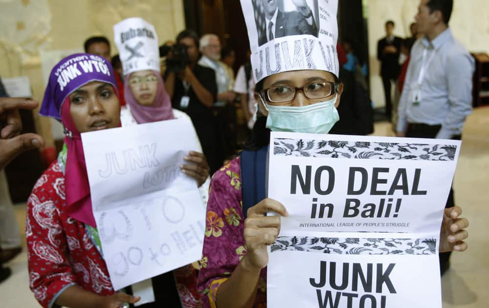 Activist holds a banner during a protest against the World Trade Organization (WTO) in Bali, Indonesia. Indonesia is hosting the World Trade Organization Ministerial Conference from Dec. 3- 6.