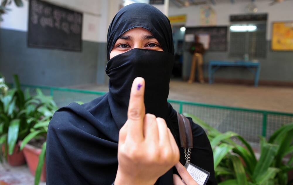 A woman shows her inked finger after casting her vote for Delhi Assembly elections, at a polling station in Delhi. Pic Courtesy- DNA