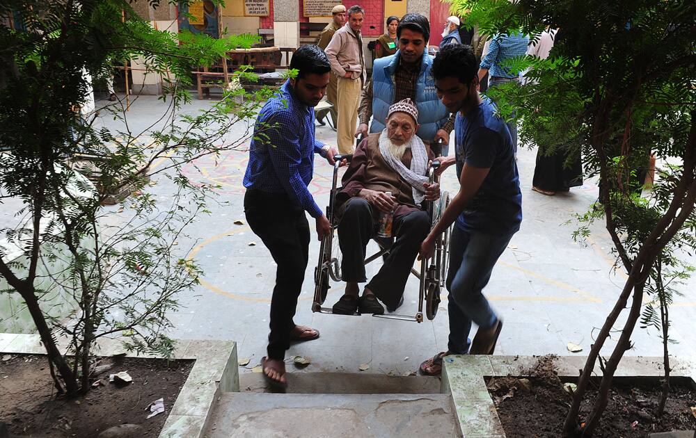 An elderly man is brought to cast his vote for Delhi Assembly elections, at a polling station in Delhi. Pic Courtesy- DNA