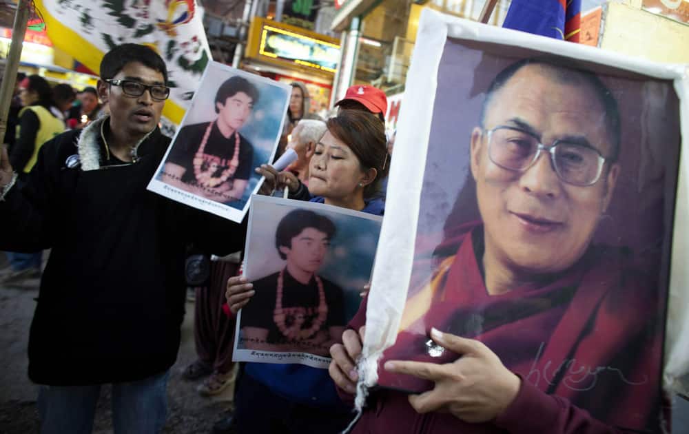 Exiled Tibetans carry a portrait of their spiritual leader the Dalai Lama during a candlelit vigil in Dharmsala.