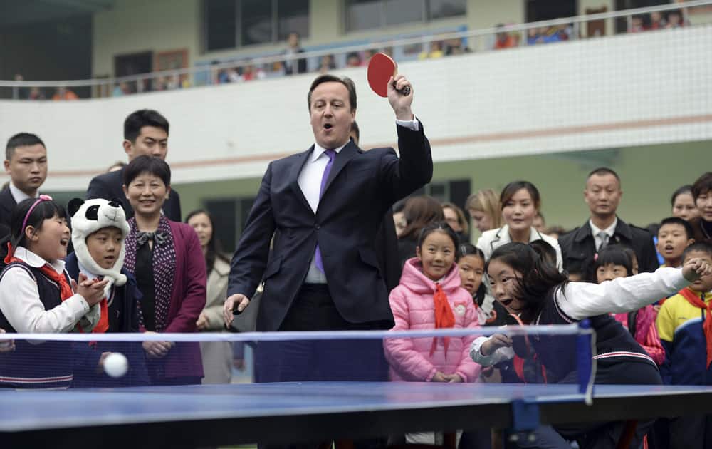 British Prime Minister David Cameron plays table tennis during his visit to a primary school in Chengdu in southwest China`s Sichuan province.
