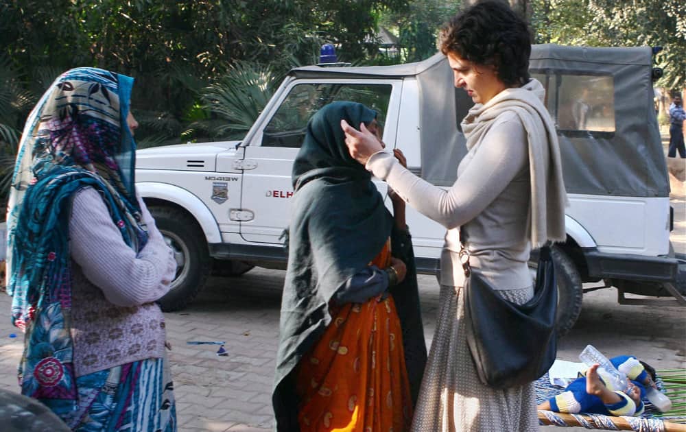 Priyanka Vadra interacts with a woman after casting vote for Delhi Assembly elections at a polling booth in New Delhi.