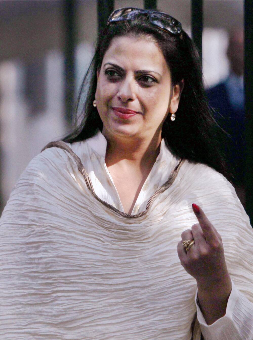 Senior BJP leader LK Advani`s daughter Pratibha shows his ink-marked finger after casting her vote for Delhi Assembly elections at a polling station in New Delhi.