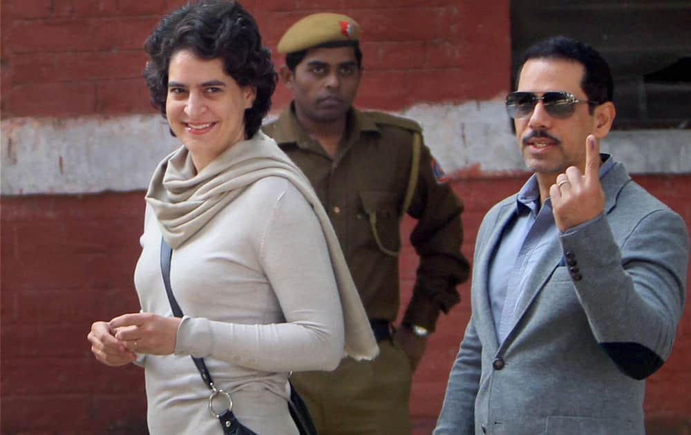 Priyanka Vadra with her husband Robert Vadra coming out after casting votes for Delhi Assembly elections at a polling booth in New Delhi.