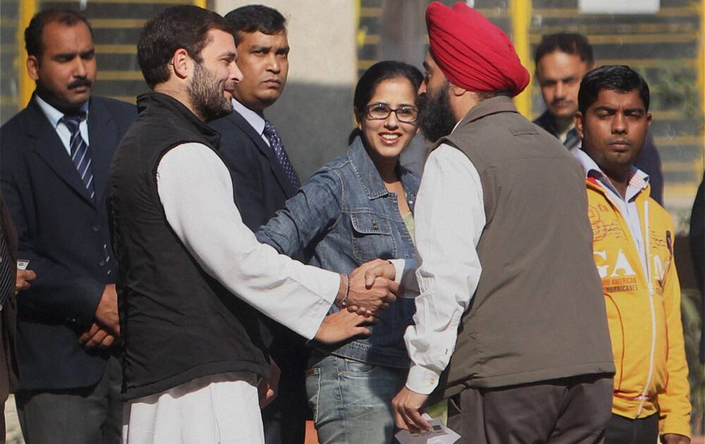 Congress Vice President Rahul Gandhi interacts with people while standing in a queue to cast his vote for Delhi Assembly elections, at a polling station in New Delhi.