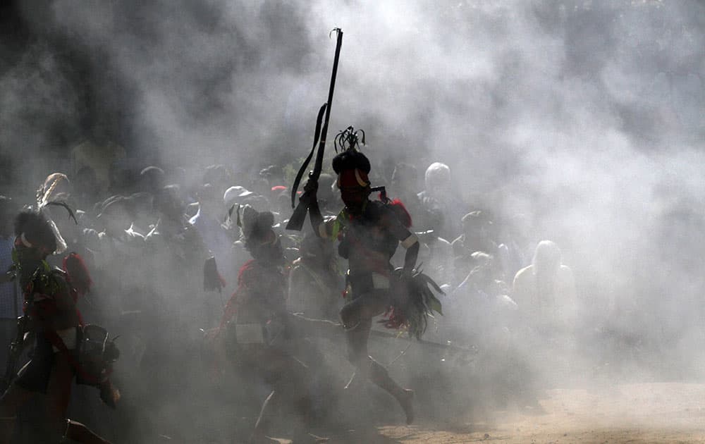 India`s Naga tribal men in traditional attire fire guns as they perform a head hunting dance during the Hornbill festival at Kisama village on the outskirts of Kohima, Nagaland, India.