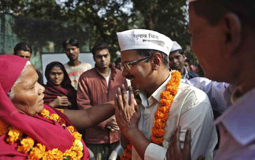 Aam Aadmi or the Common Man party candidate Arvind Kejriwal, seeks the blessings of a voter, ahead of the Delhi state assembly elections in New Delhi.