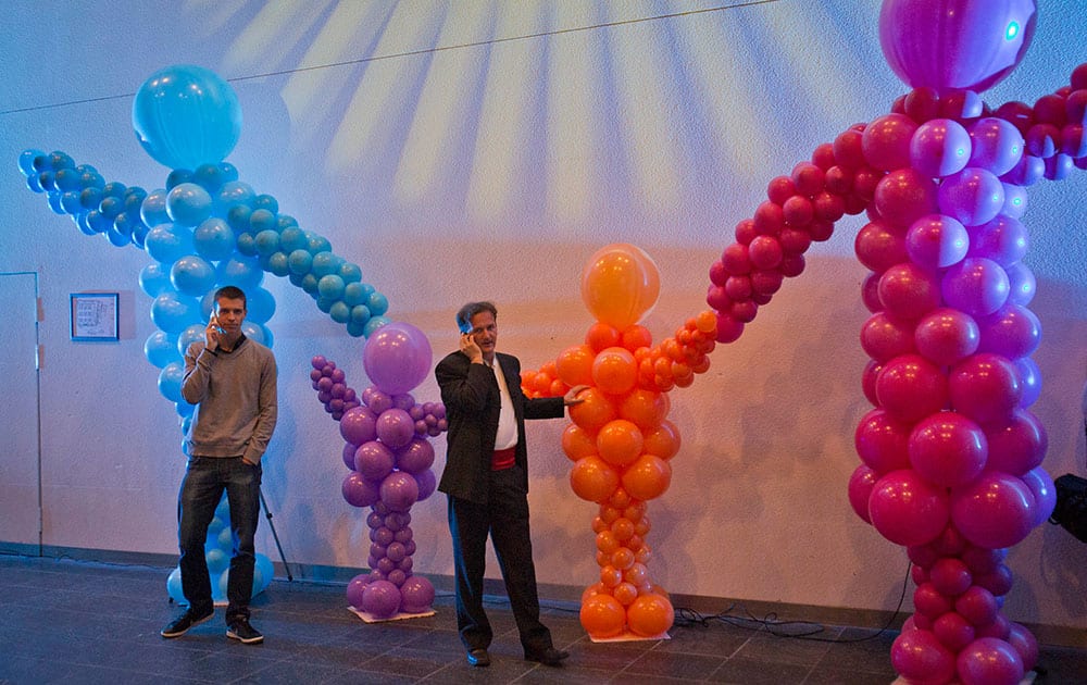 Conservative activists use their phones while standing in front of balloons representing a family as they listen to early results of the referendum at their headquarters in Zagreb, Croatia.