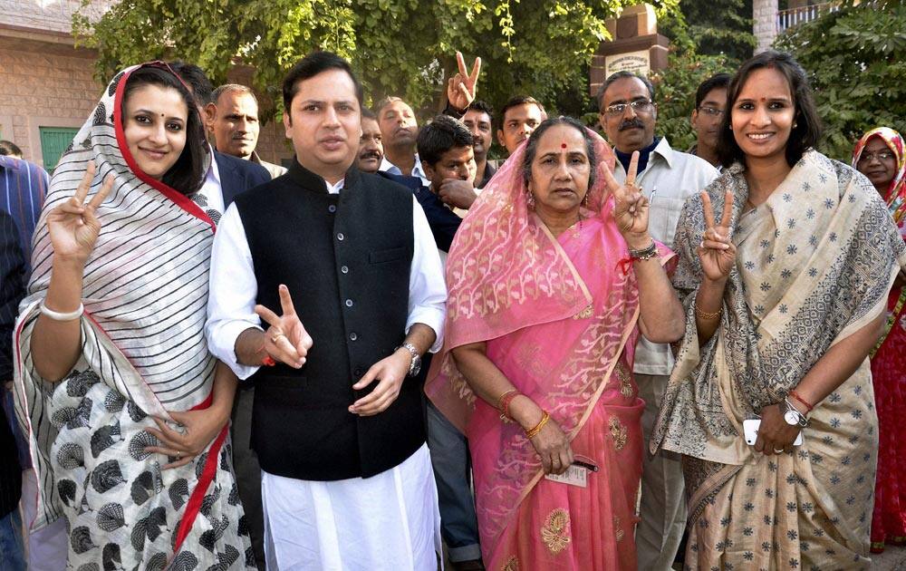 Family members of Rajasthan Chief Minister Ashok Gehlot flash victory sign after casting their vote in Jodhpur.