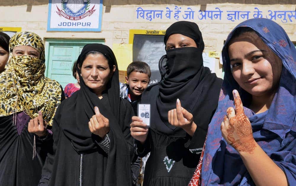 Muslim women show their ink-marked fingers after casting their votes for state assembly elections in Jodhpur.