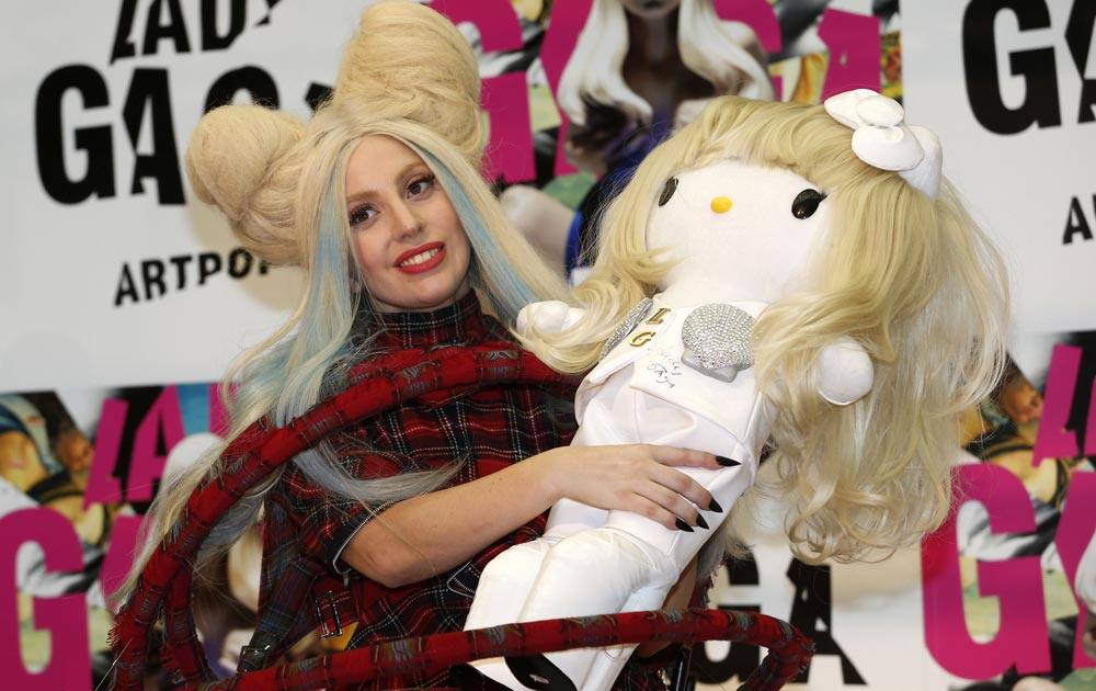 Lady Gaga poses for photographers with a Hello Kitty doll during a press conference to promote her album
