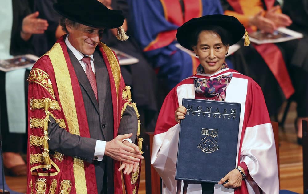 Myanmar opposition leader Aung San Suu Kyi, right, smiles as she is presented with a degree of Doctor of Laws by Monash University Chancellor Alan Finkel, in Melbourne.