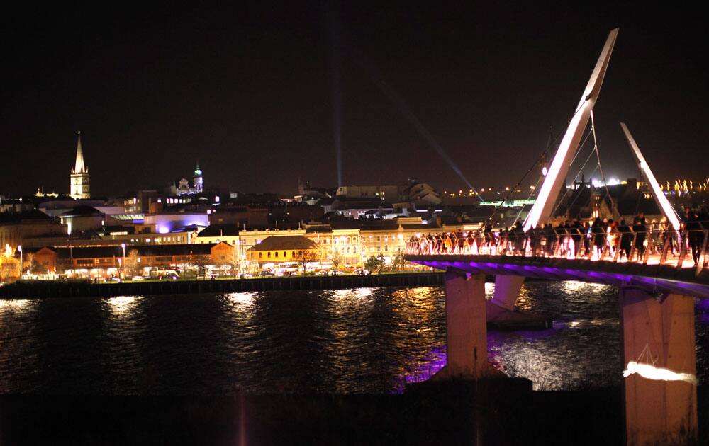 Members of the public make their way over the peace bridge to watch the Lumiere festival which is part of the UK City of Culture celebrations, in Londonderry, Northern Ireland.