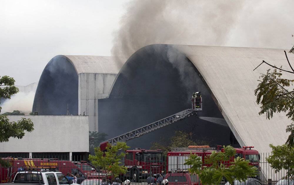 Firefighters watch from a cherry picker as water is sprayed into the Simon Bolivar Auditorium at the Latin America Memorial in Sao Paulo, Brazil.