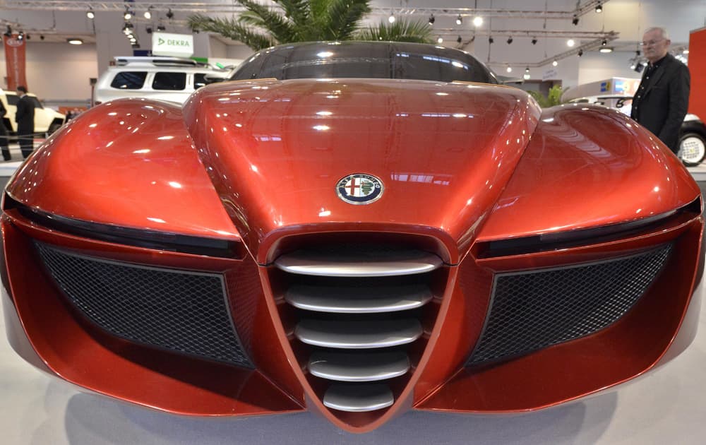A visitor looks at the concept version of an Alfa Romeo sports car at the opening of the Motor Show in Essen, Germany.