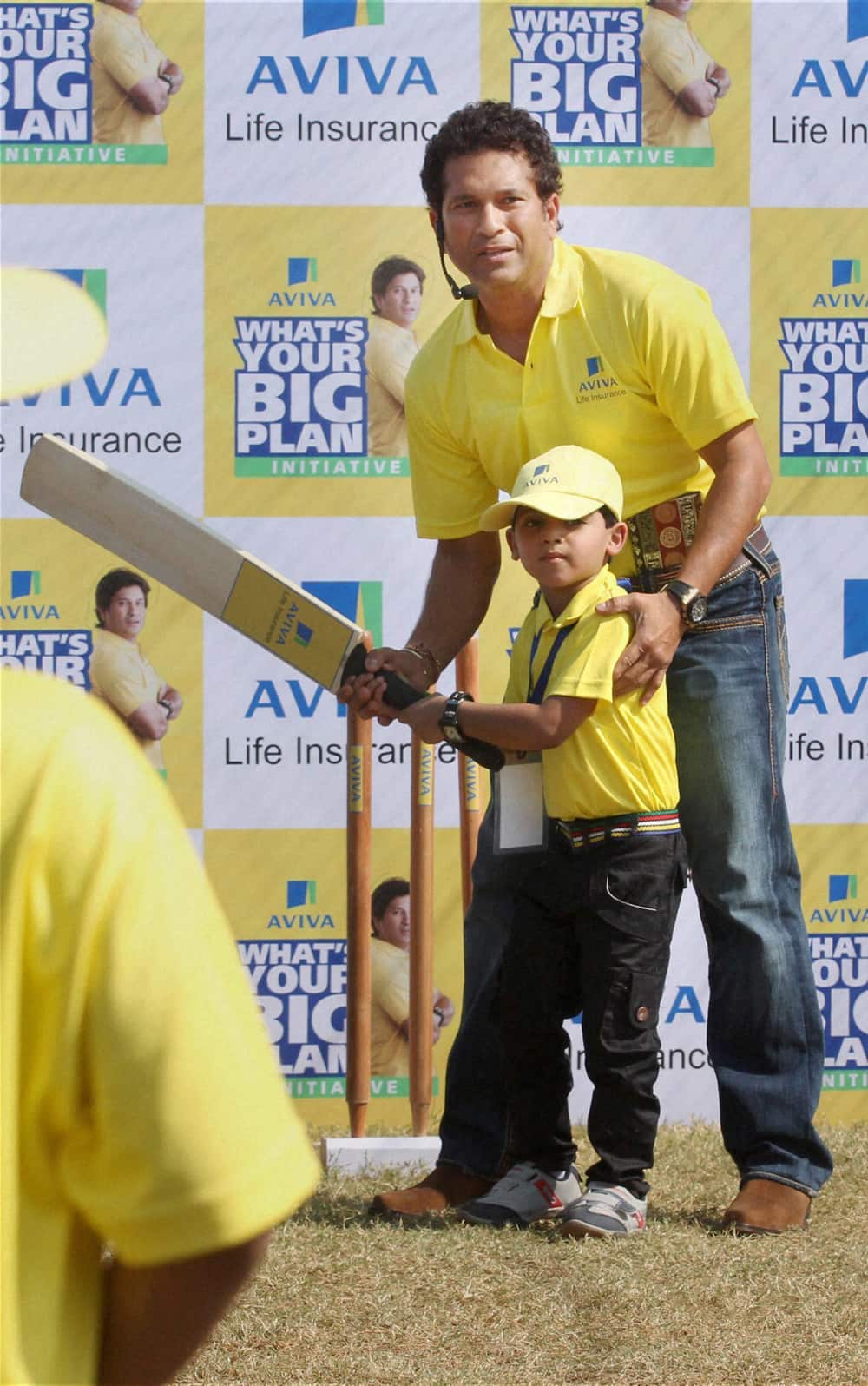 Master blaster Sachin Tendulkar gives batting tips to young child during a promotional event in Mumbai.