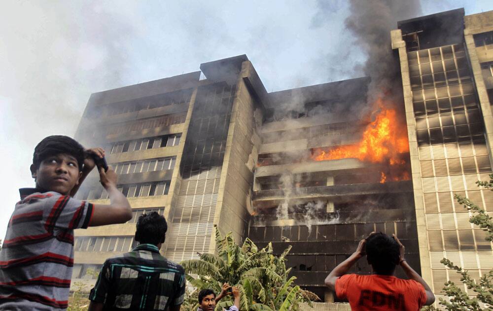 People take pictures during a fire at a nine-story garment factory in Gazipur, near Dhaka, Bangladesh.