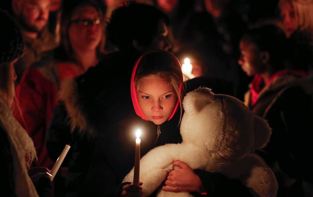 Lexi Umbarger clutches a teddy bear during a candlelight vigil in Parsons, Kan., for Cami Umbarger and her three young children – Hollie, Jaxon and Averie, who were found murdered in their Parsons home.