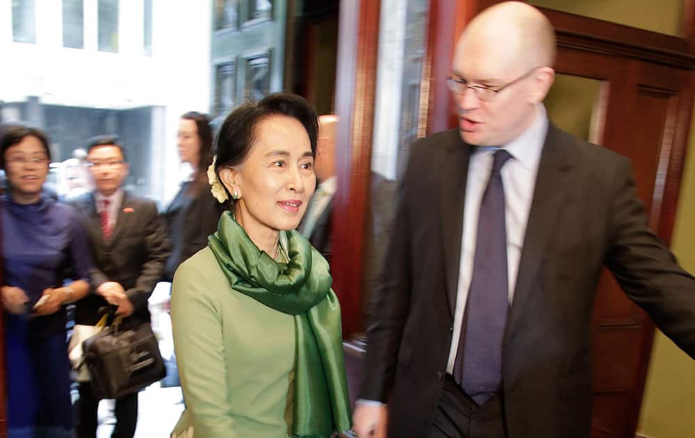 Myanmar pro-democracy leader Aung San Suu Kyi, center, arrives at the Lowy Institute in Sydney.
