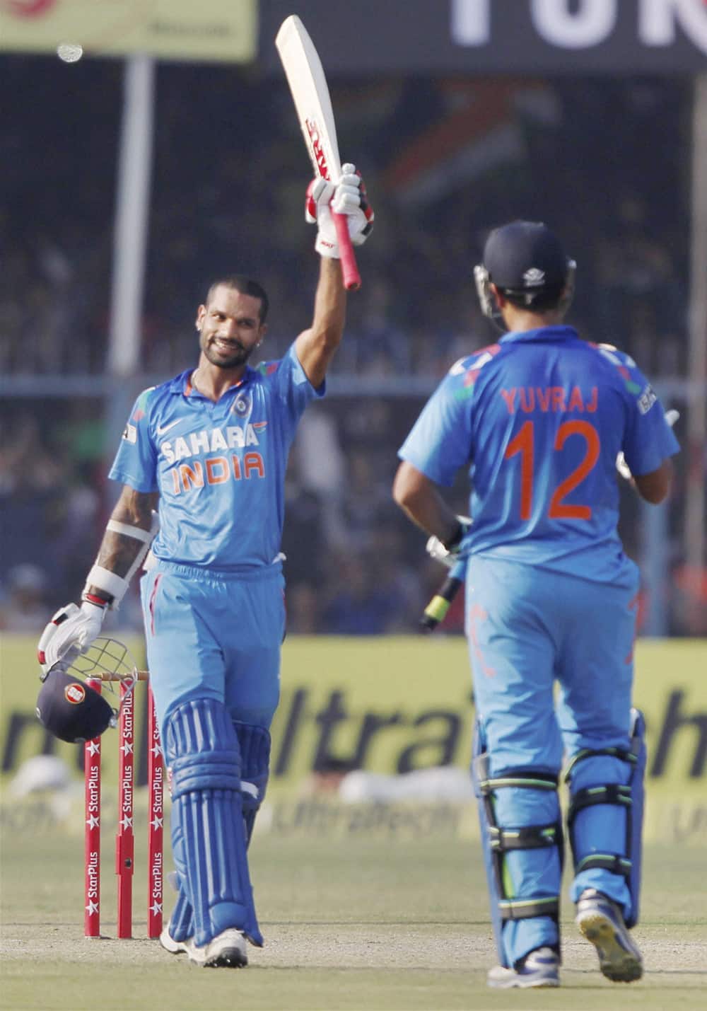 Shikar Dhawan raises the bat after his century during the last ODI cricket match against West Indies at Green Park Stadium in Kanpur.