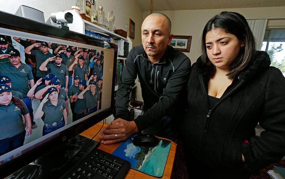 Grisel Rodriguez, right, and Jose Avila, left, pose for a photo, in their apartment in Renton, Wash. next to a computer monitor that shows a photograph of his Avila`s wife, Nestora Salgado, second from front left, who has been detained since she was arrested Aug. 21, 2013 in the state of Guerrero, south of Mexico City, where she had been leading a vigilante group targeting police corruption and drug cartel violence.