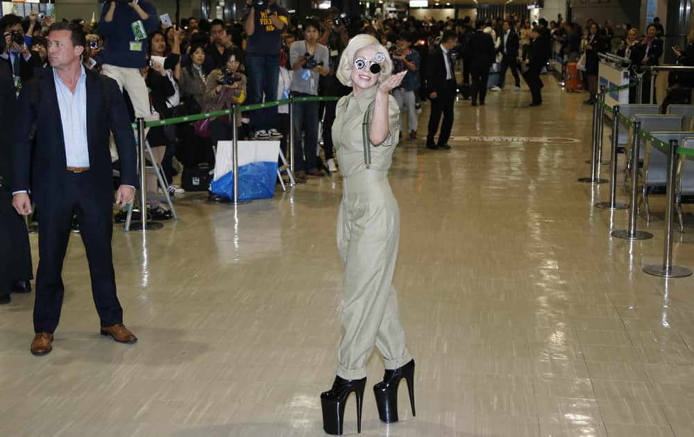 Lady Gaga waves as she is greeted by fans upon her arrival at Narita International Airport in Narita, east of Tokyo.