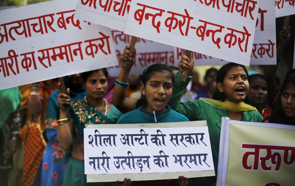Women hold placards as they shout slogans against Tarun Tejpal, editor-in-chief of Tehelka magazine, in New Delhi.