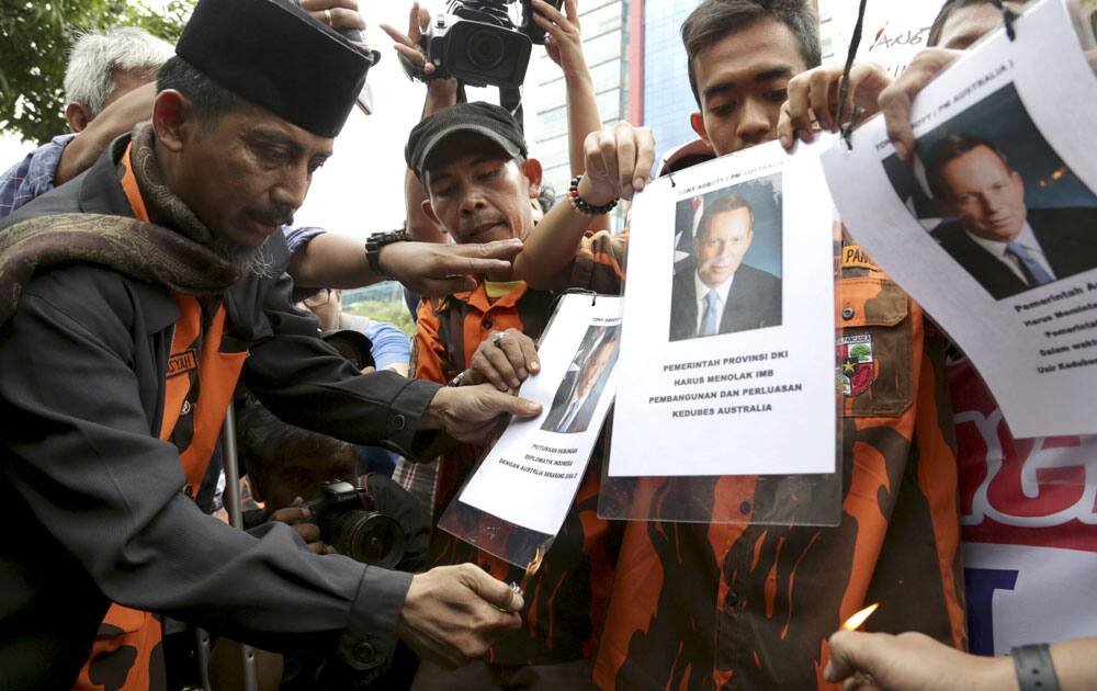 Protesters prepare to burn posters of Australian Prime Minister Tony Abbott during a demonstration against Australia`s alleged wiretapping outside Australian Embassy in Jakarta, Indonesia.