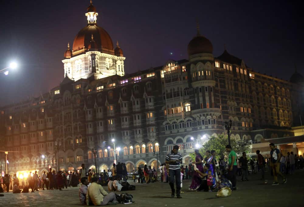 Tourists and others stand outside the Taj Mahal Palace hotel, one of the sites of 2008 terror attack, on the eve of its fifth anniversary in Mumbai.