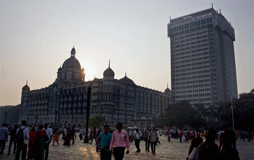 People stroll near Taj Mahal Hotel on the eve of the 5th anniversary of 26/11 terror attacks, in Mumbai.