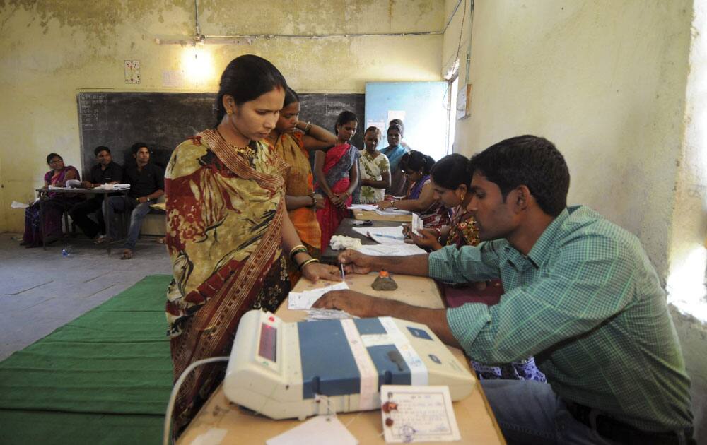 Polling officer marks the finger nail of a an Indian woman who prepares to cast her vote with election ink during the second phase of Chhattisgarh state elections in Raipur.