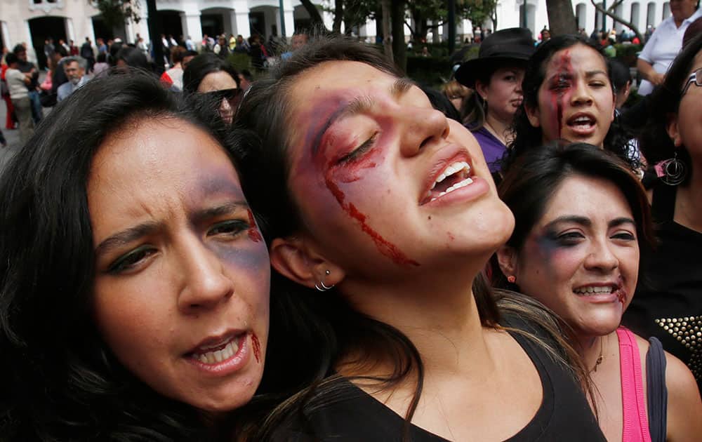 Women with fake bruises painted on their faces protest to mark the Internacional Day for the Elimination of Violence Against Women outside the government palace in Quito, Ecuador.