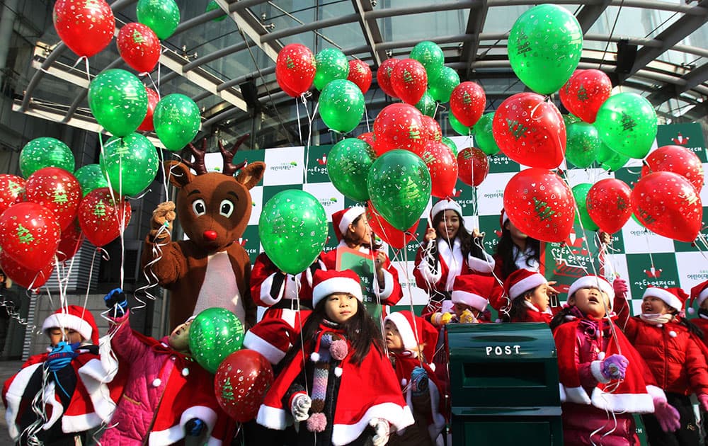 Kindergarten pupils wearing Santa Claus costumes prepare to release balloons during a campaign to raise money for a charity donation for Christmas in Seoul.